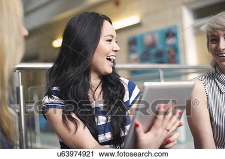 Young woman holding digital tablet, laughing View Large Photo Image Stock Image - Young woman holding digital tablet, laughing. Fotosearch