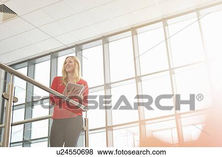 Young woman holding digital tablet View Large Photo Image Stock Photo - Young woman holding digital tablet. Fotosearch