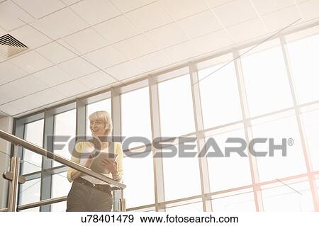 Young woman holding digital tablet View Large Photo Image Stock Photo - Young woman holding digital tablet. Fotosearch