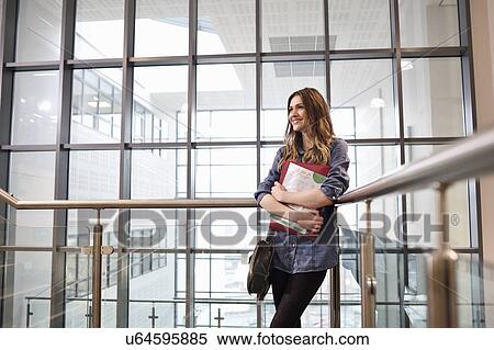 Young woman holding paperwork View Large Photo Image Stock Photography - Young woman holding paperwork. Fotosearch
