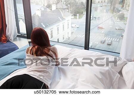 Young woman in hotel room overlooking street View Large Photo Image Stock Photography - Young woman in hotel room overlooking street. Fotosearch