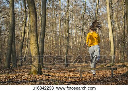 Young woman jumping fence on assault course in forest View Large Photo Image Stock Image - Young woman jumping fence on assault course in forest. Fotosearch