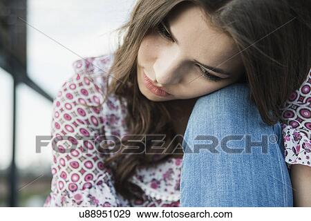 Young woman leaning head on knee View Large Photo Image Stock Photo - Young woman leaning head on knee. Fotosearch