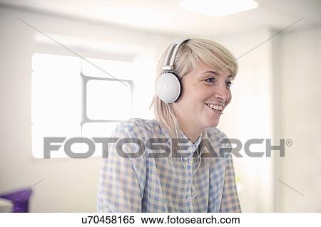 Stock Photography - Young woman listening to headphones. Fotosearch