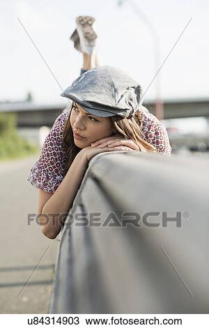 Young woman lying on front wearing flat cap View Large Photo Image Stock Image - Young woman lying on front wearing flat cap. Fotosearch