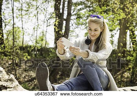 Young woman posing for self portrait in forest View Large Photo Image Stock Photo - Young woman posing for self portrait in forest. Fotosearch