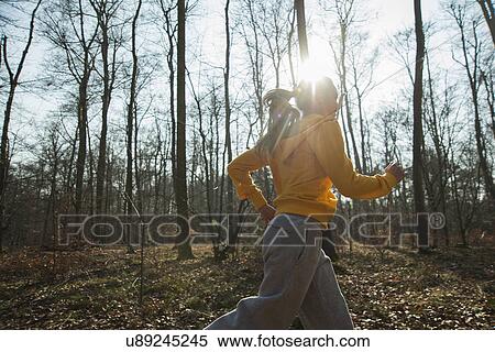 Stock Photography - Young woman running in forest. Fotosearch
