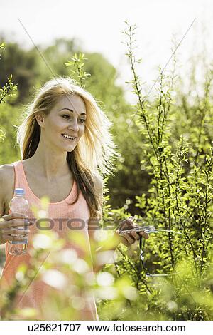 Young woman strolling in sunlit forest View Large Photo Image Stock Photo - Young woman strolling in sunlit forest. Fotosearch