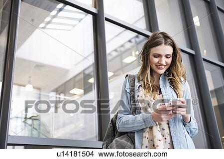 Young woman using cell phone View Large Photo Image Picture - Young woman using cell phone. Fotosearch