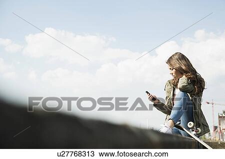 Young woman using cell phone View Large Photo Image Stock Image - Young woman using cell phone. Fotosearch