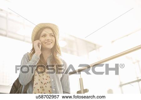 Stock Photo - Young woman using cell phone. Fotosearch