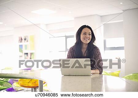 Stock Photography - Young woman using laptop. Fotosearch