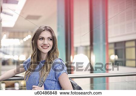 Stock Photo - Young woman wearing blue t shirt looking away. Fotosearch