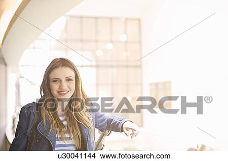 Young woman wearing denim jacket looking at camera View Large Photo Image Picture - Young woman wearing denim jacket looking at camera. Fotosearch