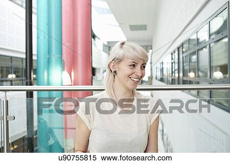 Stock Photography - Young woman with blonde hair smiling, portrait. Fotosearch