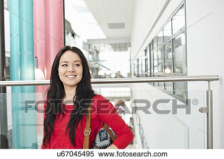 Stock Photography - Young woman with long black hair smiling, portrait. Fotosearch