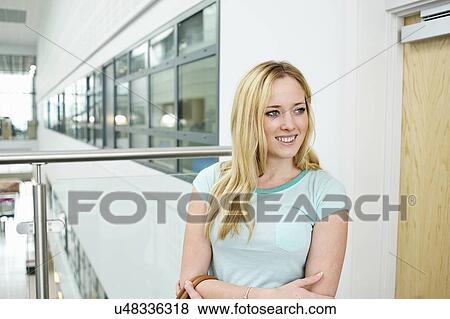 Stock Photo - Young woman with long blonde hair smiling, portrait. Fotosearch