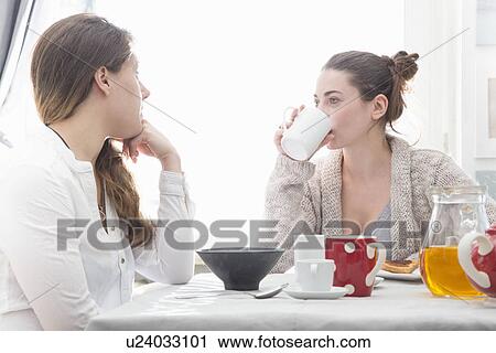 Stock Image - Young women having breakfast. Fotosearch