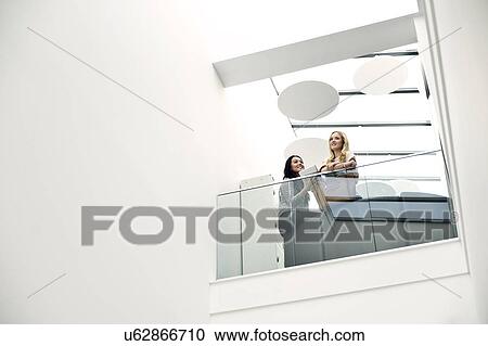 Young women on balcony, low angle View Large Photo Image Stock Image - Young women on balcony, low angle. Fotosearch