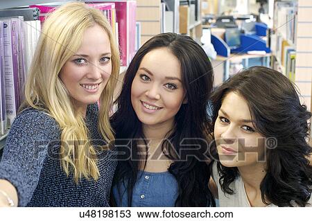 Young women photographing themselves View Large Photo Image Stock Image - Young women photographing themselves. Fotosearch