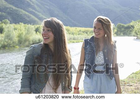 Young women standing by river View Large Photo Image Stock Image - Young women standing by river. Fotosearch