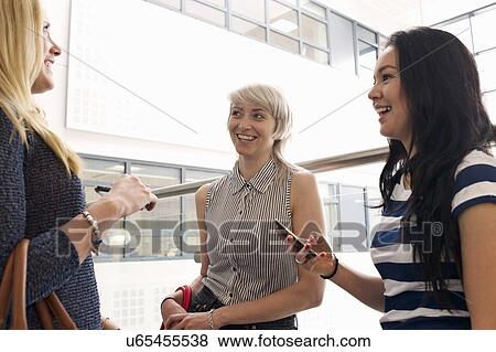 Young women using cell phones View Large Photo Image Stock Photo - Young women using cell phones. Fotosearch