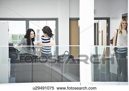 Stock Photography - Young women with digital tablet. Fotosearch
