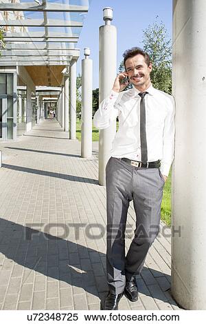 若い ビジネスマン 使うこと 携帯電話 間 上に傾斜する コラム 外 オフィス ストックフォト 写真素材 U Fotosearch