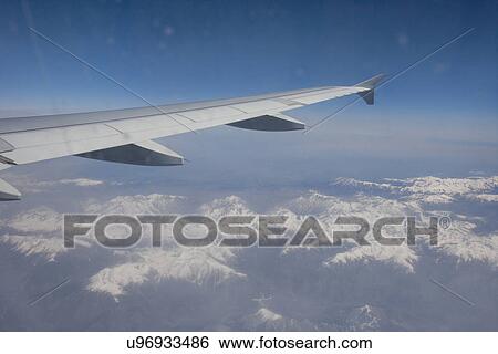 Stock Photograph - Aerial view of snow covered alps through airplane, France. Fotosearch