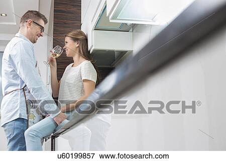 Stock Photo - Affectionate couple in kitchen. Fotosearch