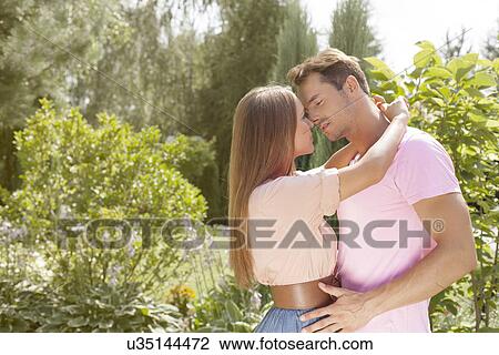 Affectionate young couple about to kiss in park View Large Photo Image Stock Image - Affectionate young couple about to kiss in park. Fotosearch