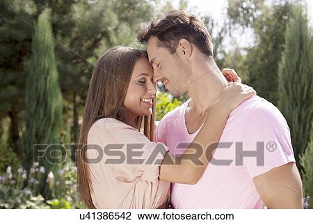 Affectionate young couple embracing in park View Large Photo Image Stock Image - Affectionate young couple embracing in park. Fotosearch
