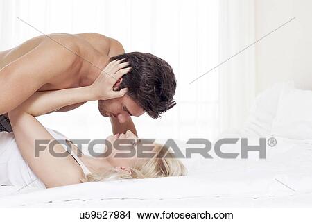 Picture - Affectionate young couple in bed. Fotosearch