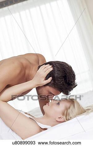 Affectionate young couple in bed View Large Photo Image Stock Image - Affectionate young couple in bed. Fotosearch