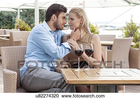 Stock Image - Affectionate young couple spending quality time at outdoor restaurant. Fotosearch