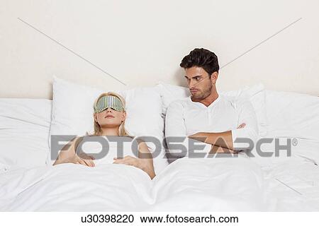 Angry young man looking at woman sleeping in bed View Large Photo Image Stock Image - Angry young man looking at woman sleeping in bed. Fotosearch
