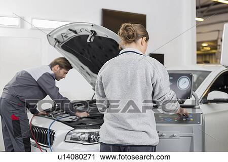 Stock Image - Automobile mechanics working in automobile repair shop. Fotosearch