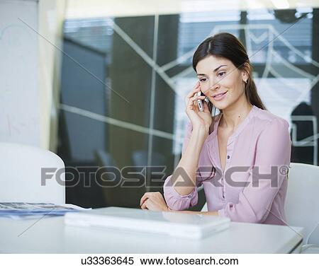 Beautiful young businesswoman using mobile phone at conference table View Large Photo Image Stock Photography - Beautiful young businesswoman using mobile phone at conference table. Fotosearch