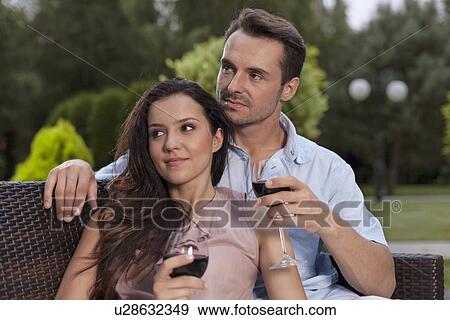 Beautiful young couple having red wine in park View Large Photo Image Stock Photo - Beautiful young couple having red wine in park. Fotosearch
