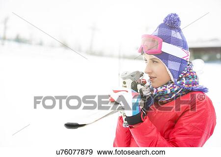 Beautiful young woman carrying skis outdoors View Large Photo Image Stock Photo - Beautiful young woman carrying skis outdoors. Fotosearch