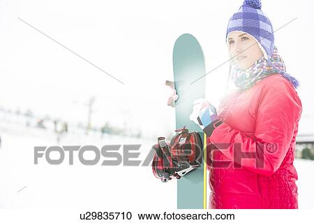 Beautiful young woman in warm clothing holding snowboard during winter View Large Photo Image Stock Image - Beautiful young woman in warm clothing holding snowboard during winter. Fotosearch