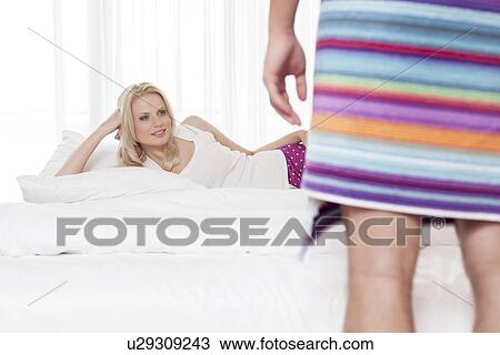 Beautiful young woman looking at man wrapped in towel at hotel room View Large Photo Image Stock Image - Beautiful young woman looking at man wrapped in towel at hotel room. Fotosearch