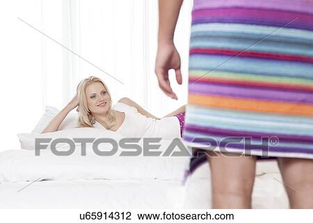 Beautiful young woman looking at man wrapped in towel at hotel room View Large Photo Image Stock Image - Beautiful young woman looking at man wrapped in towel at hotel room. Fotosearch