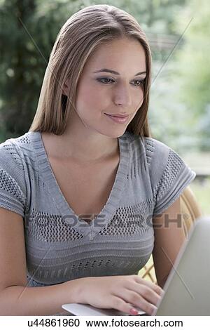 Beautiful young woman using laptop outdoors View Large Photo Image Stock Image - Beautiful young woman using laptop outdoors. Fotosearch
