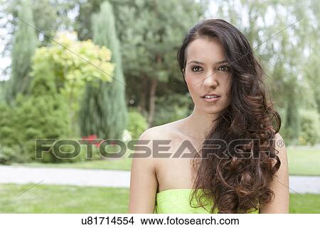 Beautiful young woman with long wavy hair in park View Large Photo Image Picture - Beautiful young woman with long wavy hair in park. Fotosearch