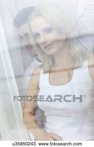 Beautiful young woman with man looking through hotel window View Large Photo Image Stock Image - Beautiful young woman with man looking through hotel window. Fotosearch