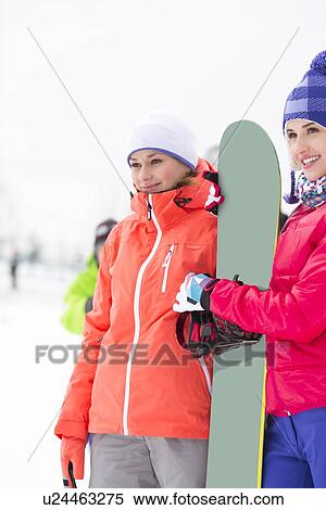 Beautiful young women with snowboard looking away View Large Photo Image Stock Photography - Beautiful young women with snowboard looking away. Fotosearch
