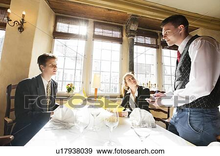 Business couple ordering food at restaurant table View Large Photo Image Stock Photo - Business couple ordering food at restaurant table. Fotosearch
