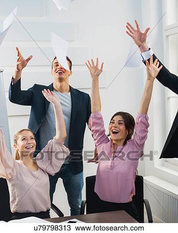 Businesspeople throwing papers in the air at office View Large Photo Image Stock Image - Businesspeople throwing papers in the air at office. Fotosearch