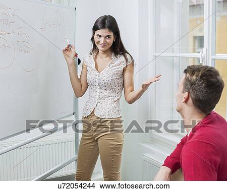 Businesswoman explaining strategy to coworker in office View Large Photo Image Picture - Businesswoman explaining strategy to coworker in office. Fotosearch